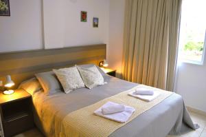 um quarto com uma cama com duas toalhas em Aires de Cataratas em Puerto Iguazú