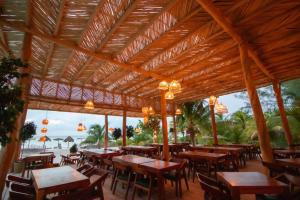 an empty restaurant with wooden tables and chairs at My Blue Hotel Holbox in Holbox Island