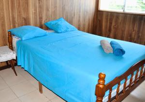 a bed with blue sheets and blue pillows on it at Villa Des Sources Chaudes in Bouillante