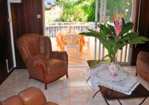 a living room with two chairs and a table at Villa Des Sources Chaudes in Bouillante