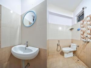 カラングートにあるDolphin service apptmentのバスルーム(洗面台、トイレ、鏡付)