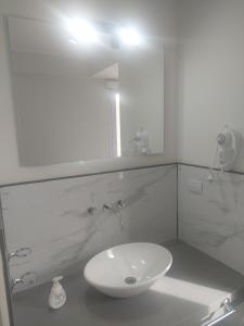 a white bathroom with a sink and a mirror at Calidez, confort y relax. in Trelew