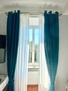 una ventana con cortinas azules y blancas en una habitación en Upi-Up Rome Staying en Roma
