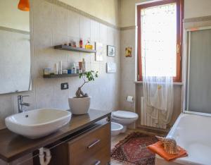 łazienka z umywalką, toaletą i oknem w obiekcie A Casa di Lidia 15 min dal Lago di Garda e Verona Centro Vicinissima Terme Acquardens w mieście Fumane