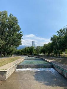 a water fountain in a park with trees in the background at Отличная квартира со всеми удобствами. in Almaty