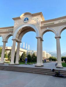 a large building with columns with a skateboard under it at Отличная квартира со всеми удобствами. in Almaty