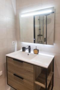 een badkamer met een witte wastafel en een spiegel bij LIKE CASA- Centre/Gare in Valence
