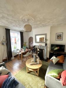 ein Wohnzimmer mit einem Sofa und einem Tisch in der Unterkunft Leeds Cosy House in Leeds
