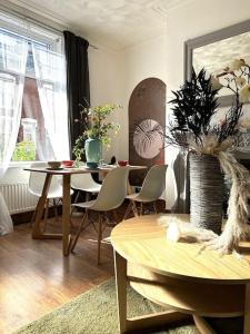 a living room with a table and chairs and a table and a tableablish at Leeds Cosy House in Leeds