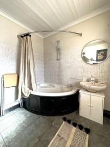 a bathroom with a bath tub and a sink at Leeds Cosy House in Leeds