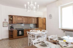 a kitchen with wooden cabinets and a table with chairs at Casa Giovanni XXIII Assisi in Assisi