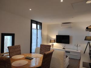 a living room with a table and chairs and a television at Escapade Périgourdine in Trélissac