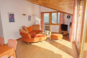 ein Wohnzimmer mit einem Stuhl und einem TV in der Unterkunft Haus Alpsägu, Bettmeralp in Bettmeralp