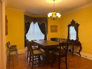 uma sala de jantar com paredes amarelas e uma mesa e cadeiras em the red star room C em Cataratas do Niágara
