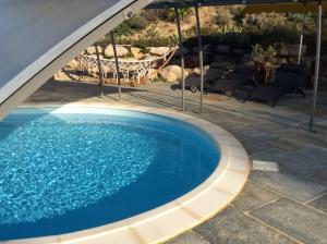 a large blue swimming pool under an umbrella at Appartement les Ecureuils in La Roque-dʼAnthéron