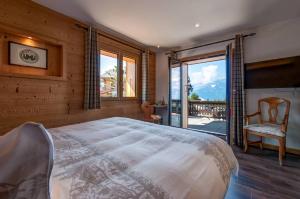a bedroom with a large bed and a balcony at Alpe Fleurie Hôtel & Restaurant in Villars-sur-Ollon