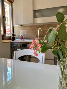 una cocina con un jarrón de flores sobre una mesa en Edulis 1 en Arenas de San Pedro