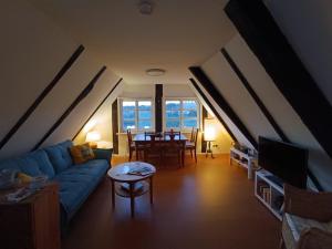 a living room with a blue couch and a table at Fischerhaus Herstelle in Beverungen +11 photos