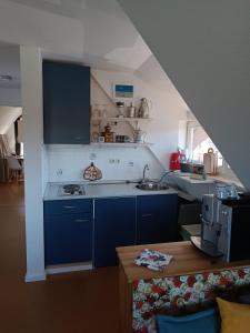 una cocina con armarios azules y fregadero en Fischerhaus Herstelle, en Beverungen