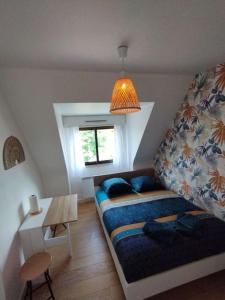- une chambre avec un lit, une table et une fenêtre dans l'établissement Le ptit nid de Louviers TV/Fibre, à Louviers