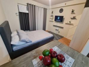 Un dormitorio con una cama y una mesa con fruta. en Cebu One Oasis Fully Furnished Studio with balcony, en Carreta