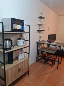 Habitación con cocina con microondas y mesa. en Cebu One Oasis Fully Furnished Studio with balcony, en Carreta