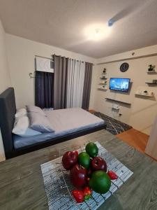 Cette chambre comprend un lit et une table avec des fruits. dans l'établissement Cebu One Oasis Fully Furnished Studio with balcony, à Carreta