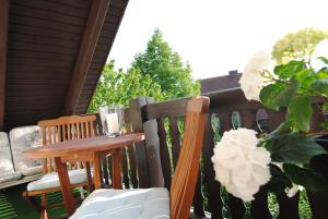 uma mesa e cadeiras num alpendre com flores em Ferienwohnung Sonne em Bad Windsheim