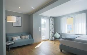 a bedroom with a bed and a couch and a window at Haus Welzel in Dresden