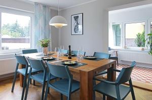 comedor con mesa de madera y sillas azules en Haus Welzel en Dresden