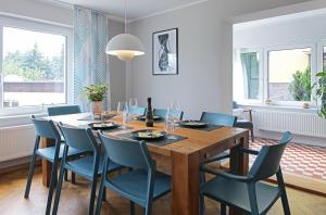 a dining room with a wooden table and blue chairs at Haus Welzel in Dresden