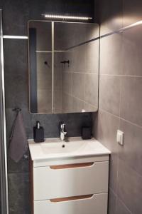 La salle de bains est pourvue d'un lavabo blanc et d'un miroir. dans l'établissement Apartament Carolina, à Rzeszów