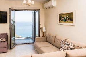 a living room with a couch and a sliding glass door at TOPAZ AGIOS NIKITAS in Agios Nikitas