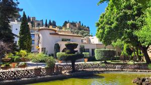 uma vista para um edifício com um lago e árvores em Superbe appartement piscine, tennis, vue mer et décoré avec goût em Cassis