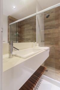 ein weißes Badezimmer mit einem Waschbecken und einem Spiegel in der Unterkunft Flat Ocean View II in Rio de Janeiro