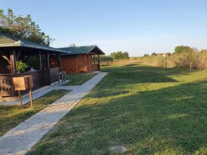 a cabin in a field next to a grass field at Bungalov Lenka in Temerin