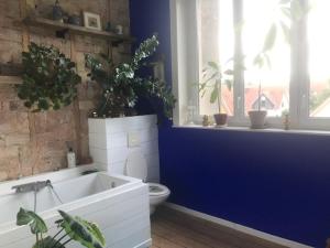 baño con aseo y bañera con plantas en Rose's room en Saint-Léonard