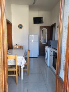 een keuken met een tafel en een witte koelkast bij B&B Figura Apartments in Borgo San Lorenzo