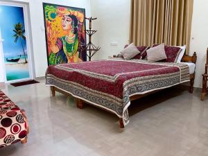 een slaapkamer met een groot bed en een schilderij aan de muur bij Aryavilla Heritage in Varkala
