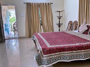 a bedroom with a bed with a red comforter at Aryavilla Heritage in Varkala