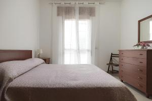 1 dormitorio con cama, tocador y espejo en Liammare, en Mondragone