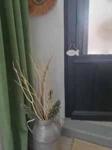 een vaas met een plant naast een raam bij Kaiola in Saint-Georges-de-Didonne