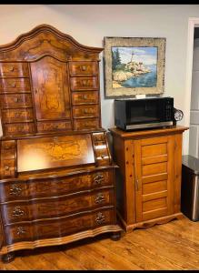 een slaapkamer met een grote houten dressoir en een magnetron bij Gather-on-Trent, Your Private Waterfront Luxury Resort in Trent Hills in Campbellford