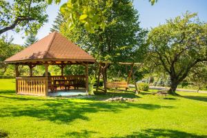 a wooden gazebo in a park with green grass at Zielona Plaża in Bereżnica Wyżna