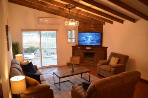sala de estar con sofás, TV y chimenea en Finca Jorsan en Ensenada