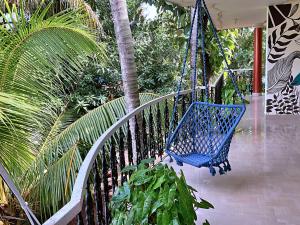 een blauwe schommel op een veranda met een palmboom bij Aryavilla Heritage in Varkala
