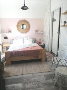 een slaapkamer met een bed en een spiegel aan de muur bij Kaiola in Saint-Georges-de-Didonne
