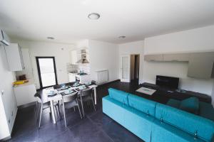 a living room with a blue couch and a kitchen at BLU OCEANO (Casa Vacanza) in Guardialfiera