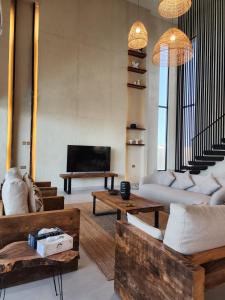 a living room with couches and a flat screen tv at The Gate in Sur