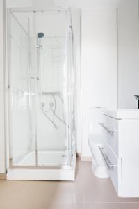 a white bathroom with a shower and a toilet at S54 - Private Rooms in the City Center in Bergen